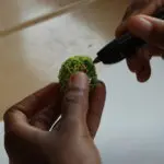 Handen die een bol vasthouden en een 3D Printerpen.