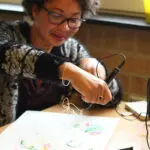 Een vrouw probeert vormen te maken tijdens een 3D Pen Tekenen Workshop voor volwassenen.