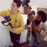 Leerlingen helpen met de apparatuur voor de promotiefilm van de school