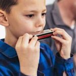 Kinderen leren mondharmonica spelen in onze workshop voor scholen en bso's