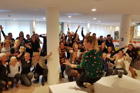 Workshop voor een grote groep volwassenen met workshopleider.